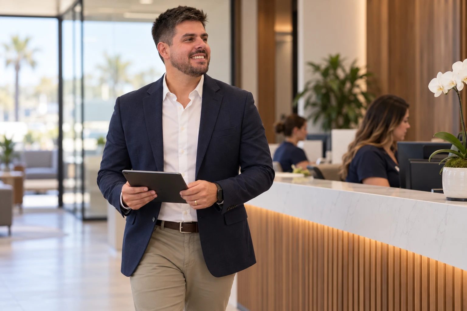Pedro Monteiro walking through the front office of a professional-services business with a tablet