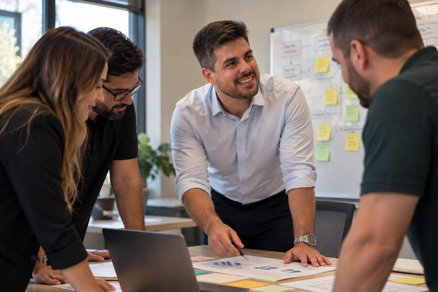 Pedro Monteiro in a working session with a team around a table covered with process maps